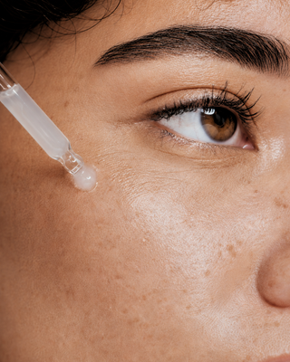 Close-up of dropper applying DermaReverse serum to skin near the eye